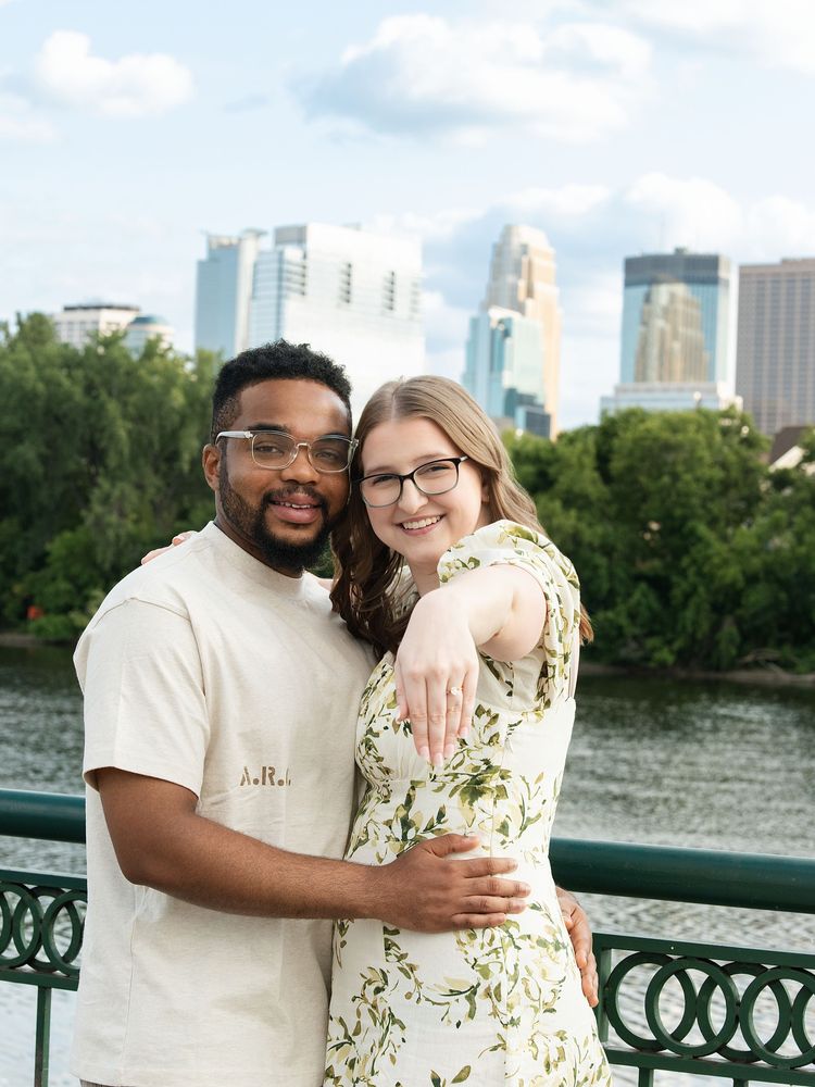Couple showing the engagement ring by the river
