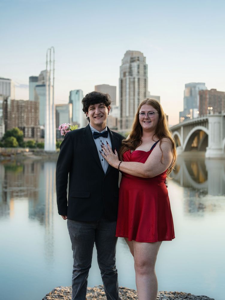 Couple by the river with the Minneapolis skyline