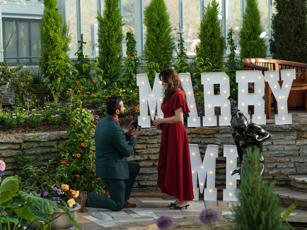 Proposal in a garden with MARRY ME letters