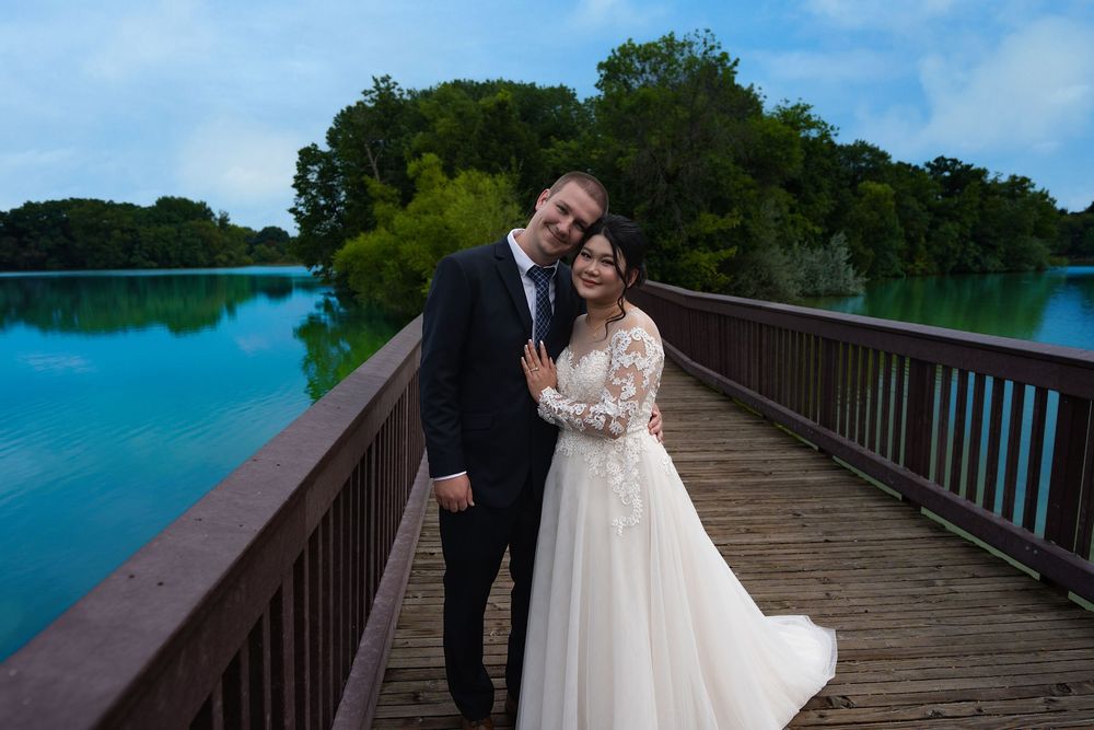Newlyweds on a wooden boardwalk over a turquoise lake